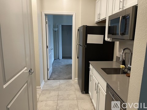 A kitchen with black appliances and white cabinets.