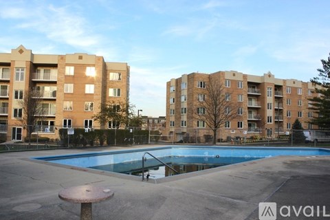 A large swimming pool in front of apartment buildings.