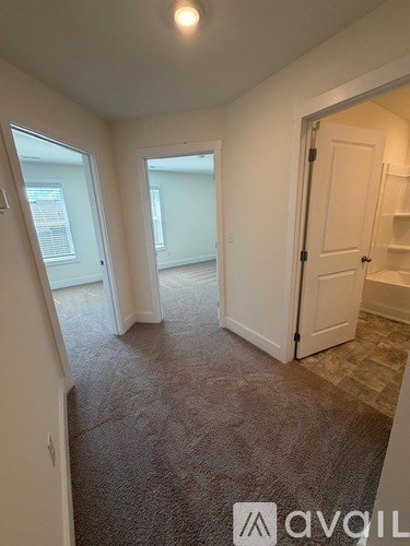 A carpeted room with a door and a window.