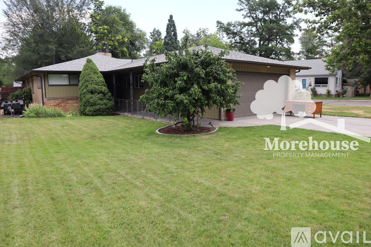 A house with a lawn and trees in front of it.