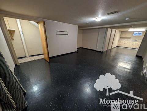 A spacious room with a Morehouse Property logo on the floor.