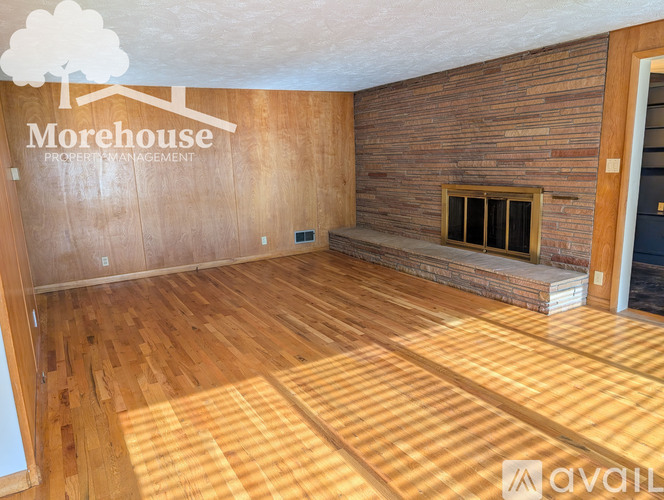 A room with wooden flooring and a fireplace is available for rent.