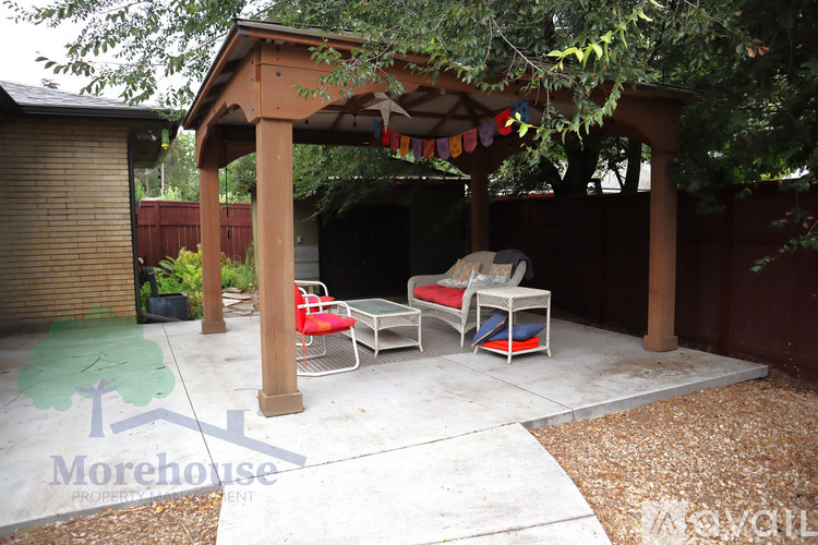 A patio with a table and chairs under a pergola.