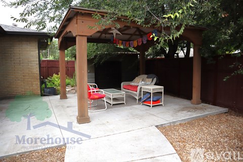 A patio with a table and chairs under a pergola.