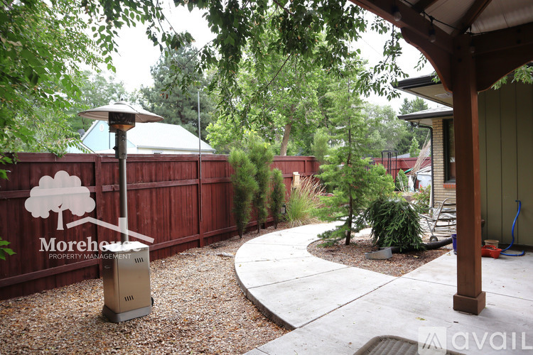 A backyard with a Morehea sign and a trash can.