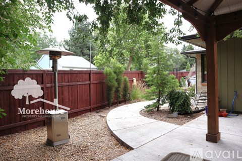A backyard with a Morehea sign and a trash can.