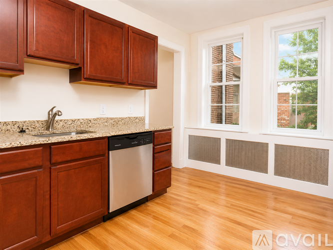 A kitchen with wooden cabinets and a stainless steel dishwasher.