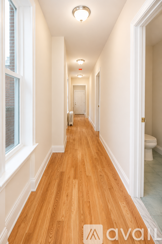 A long hallway with wood floors and white walls.