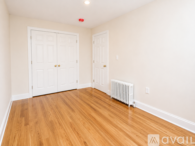 A room with two doors and a radiator on the floor.