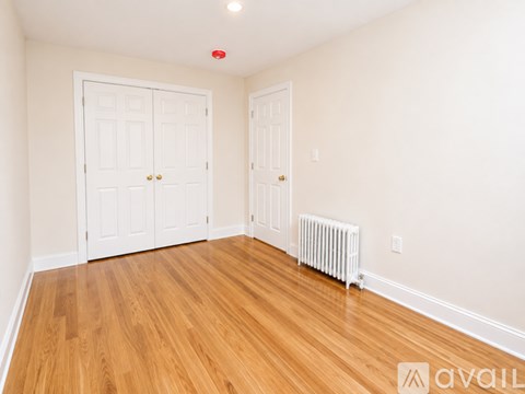 A room with two doors and a radiator on the floor.