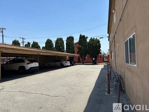 A parking lot with cars parked and a building on the right side.