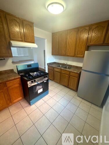 A kitchen with wooden cabinets and a black stove top oven.