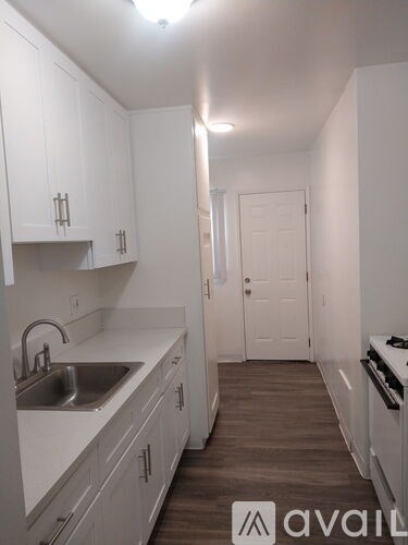 A kitchen with white cabinets and a sink.