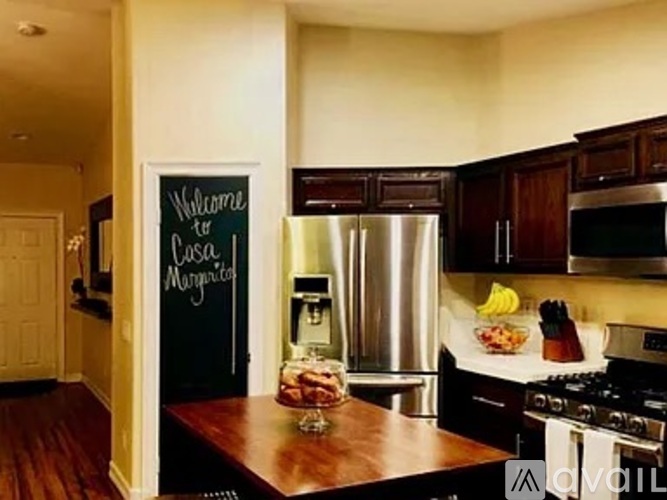 A kitchen with a chalkboard sign that says "Welcome to Casteel Mansion".