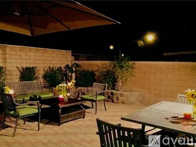 A patio with a table and chairs under an umbrella.