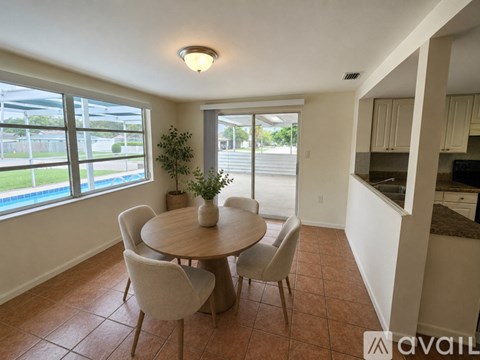 A dining room with a round table and chairs.