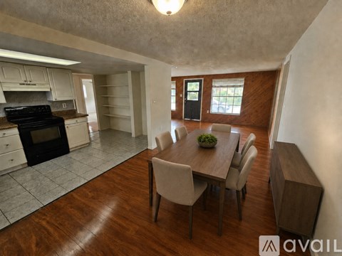 A kitchen with a dining table and chairs.