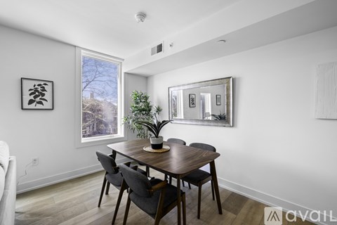 A dining room with a wooden table and chairs.
