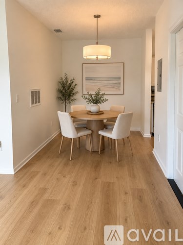 A dining room with a wooden table and chairs.