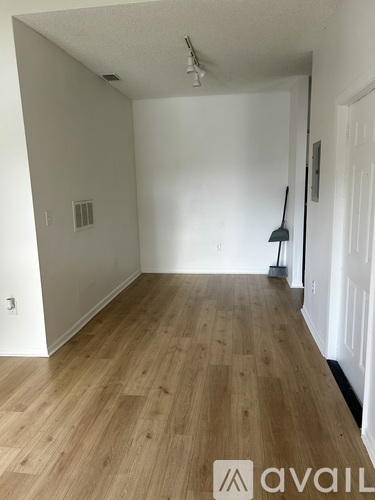 A room with wooden flooring and white walls.