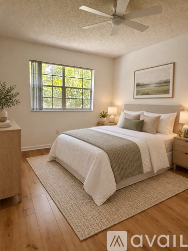 A bedroom with a bed, nightstand, and window.