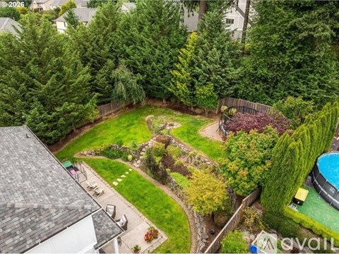 A backyard with a pool and a small garden.