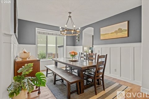 A dining room with a wooden table and chairs.