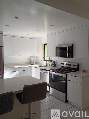 A modern kitchen with white cabinets and appliances.