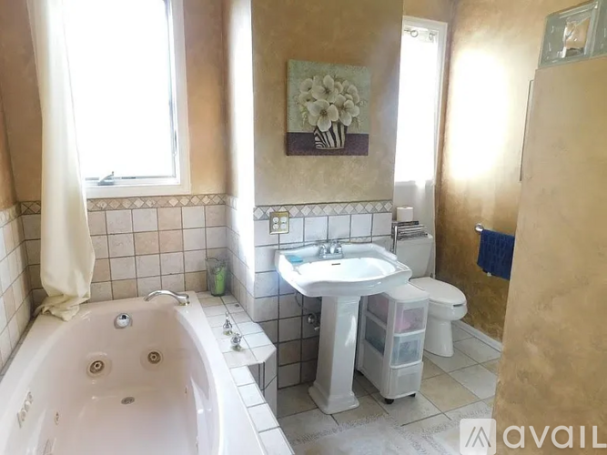 A bathroom with a white tub, sink, and toilet.