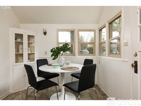 A white dining room with a round table and chairs.