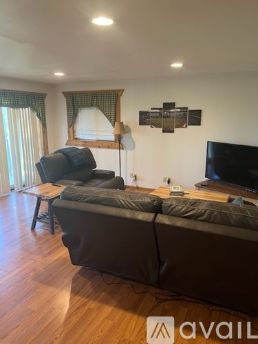 A living room with a couch, chair, and television.