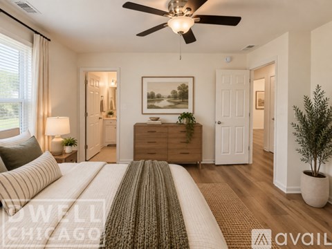 A well decorated bedroom with a bed in the foreground and a painting on the wall.