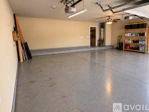 A spacious garage with a concrete floor and a fan on the ceiling.