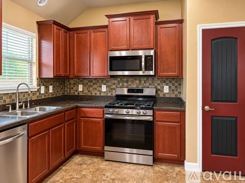 A kitchen with wooden cabinets and a black stove top oven.
