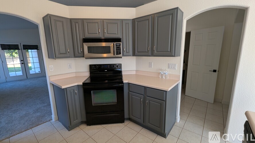 A kitchen with a black oven and microwave.