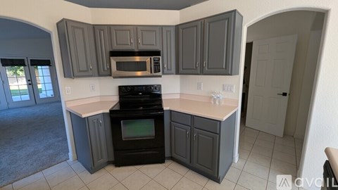 A kitchen with a black oven and microwave.