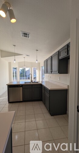 A kitchen with black cabinets and a white countertop.