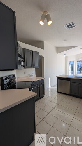 A kitchen with black cabinets and a white countertop.