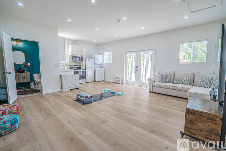 A living room with a couch, a television, and a kitchen area in the background.