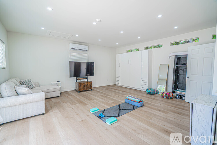A living room with a white couch and a television on a wooden stand.