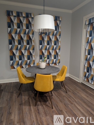 A dining room with a round table and yellow chairs.