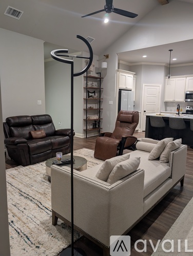 A living room with a white couch and a black leather chair.