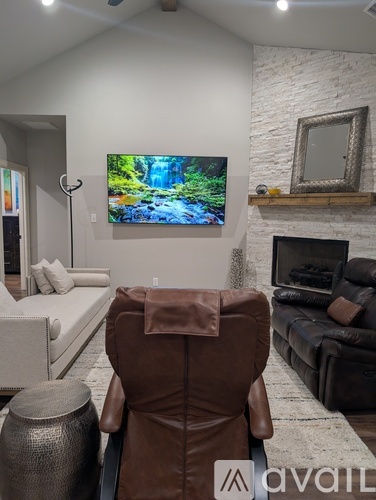 A living room with a brown leather chair facing a television.