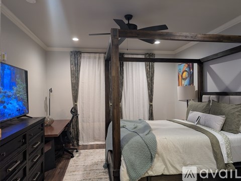 A bedroom with a four poster bed and a television.
