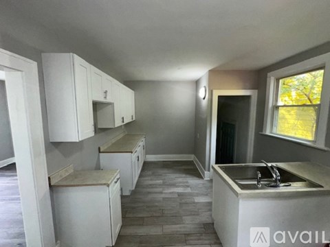 A kitchen with white cabinets and a countertop with a sink.