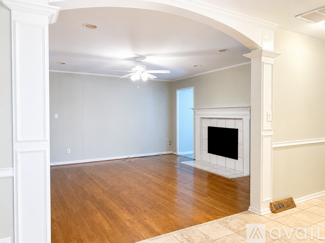 A living room with a fireplace and a ceiling fan.