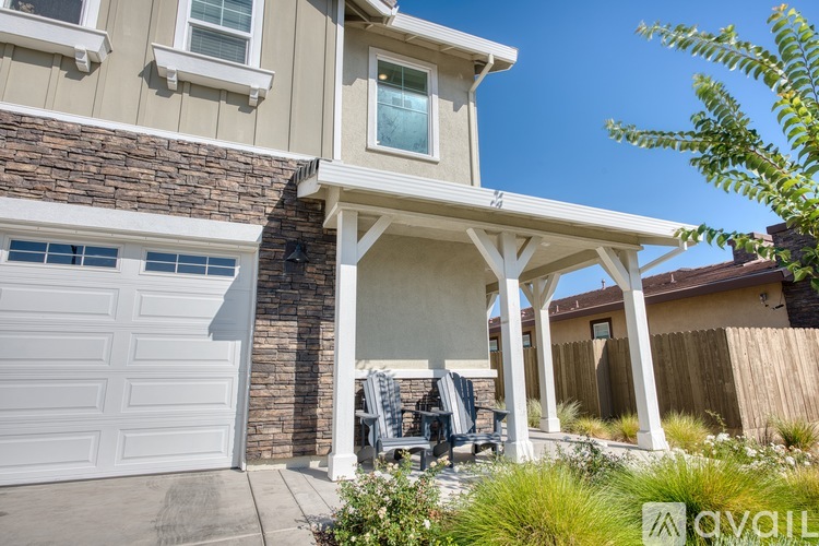 A house with a covered patio and a garage door.