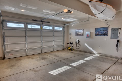 A spacious garage with a large overhead light and a wall-mounted bike rack.