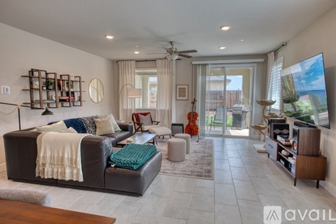 A living room with a couch, a chair, a coffee table, a TV, and a guitar.