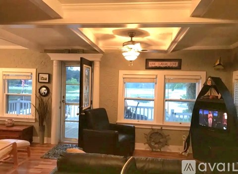 A living room with a couch, chair, and a television.